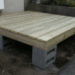 Plateforme en bois surclavee sur blocs de beton gris