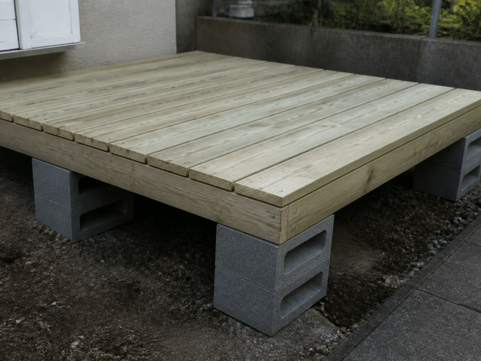 Plateforme en bois surclavee sur blocs de beton gris